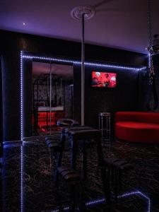 a bar with stools and a red couch at Love Room- Adult Only in Bucharest