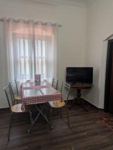 a dining room with a table and chairs and a television at HILL TOP HOMES in Kannur