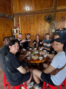 a group of people sitting around a wooden table at PhinFamilyHomestay in Tả Van