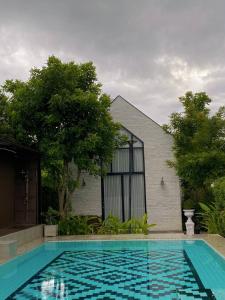 a swimming pool in front of a house at Phuping Valley Resort in Tak