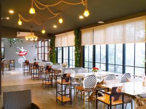 a restaurant with tables and chairs and windows at Phuping Valley Resort in Tak