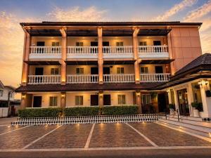 a large building with a courtyard in front of it at The Lion King Hotel by Thai Baan Ozone Udonthani in Udon Thani
