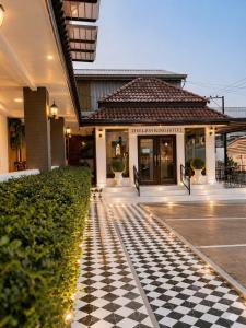 a hotel with a checkered floor in front of a building at The Lion King Hotel by Thai Baan Ozone Udonthani in Udon Thani