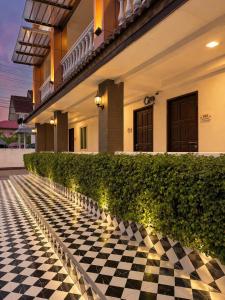 a checkered floor in front of a house with lights at The Lion King Hotel by Thai Baan Ozone Udonthani in Udon Thani