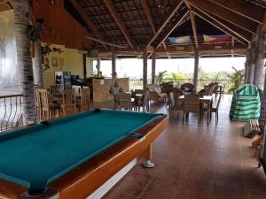 a pool table in a room with tables and chairs at The Halfway Cafe-Dauin, Glamp1 - Cricket in Dauin