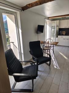 a room with chairs and a table and a balcony at Studio Les Restanques in Montbrun-les-Bains