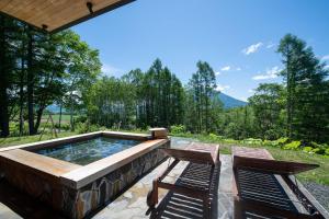 a patio with two chairs and a hot tub at Kazahana at Hanaridge in Kutchan