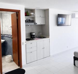 a kitchen with white cabinets and a sink at Loft playa y mar in Cartagena de Indias +10 photos