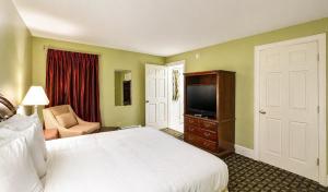 a hotel room with a bed and a television at Colonial Motel in Brattleboro