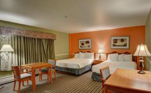 a hotel room with two beds and a table at Colonial Motel in Brattleboro