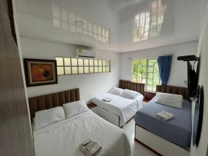 a small room with two beds and a window at Finca Altamira in La Vega +30 photos