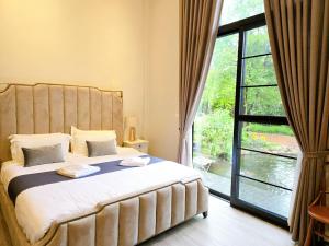a bedroom with a large bed and a large window at Phuping Valley Resort in Tak +65 photos