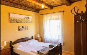a bedroom with a bed and a window at Old House Piperi in Podgorica