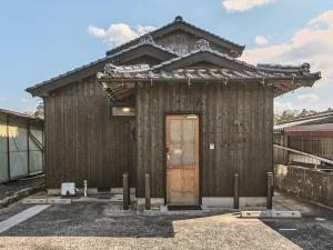 a small wooden building with a wooden door at 縁や出雲 in Taisha