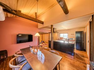 a dining room and living room with a table and chairs at 縁や出雲 in Taisha