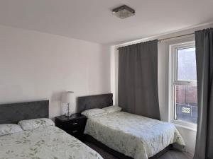 a bedroom with two beds and a window at Gillingham Hidden Gem in Gillingham