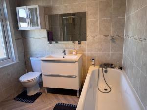 a bathroom with a sink and a toilet and a tub at Gillingham Hidden Gem in Gillingham +13 photos
