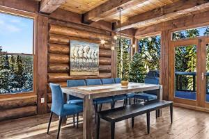 a dining room with a table and blue chairs at 4-Bedroom Chalet Fraternite in Lac-Superieur Tremblant in Lac-Superieur
