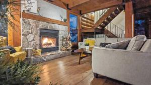 a living room with a couch and a fireplace at 4-Bedroom Chalet Fraternite in Lac-Superieur Tremblant in Lac-Superieur