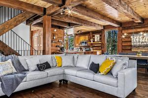 a living room with a gray couch with yellow pillows at 4-Bedroom Chalet Fraternite in Lac-Superieur Tremblant in Lac-Superieur +50 photos