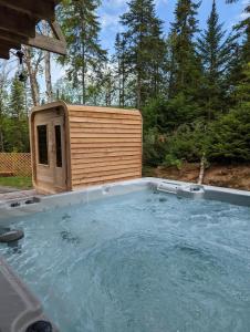 a hot tub with a dog house in a backyard at 4-Bedroom Chalet Fraternite in Lac-Superieur Tremblant in Lac-Superieur
