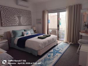 a bedroom with a large bed and a balcony at The Boathouse a 3 Bedroom Holiday Home in Narooma
