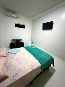 a bedroom with a bed and a tv on the wall at Quarto privado próximo ao centro 3 in Manaus