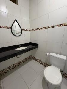 a bathroom with a white toilet and a sink at Quarto privado próximo ao centro 3 in Manaus