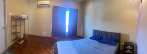a bedroom with a bed with blue sheets and a window at Dotties House in Subang Jaya +5 photos