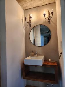 a bathroom with a sink and a mirror at La Choza - Refugio para dos in La Falda +22 photos