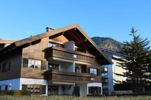 an apartment building with wooden balconies and a tree at Ferienwohnung G. Füglein in Oberstdorf