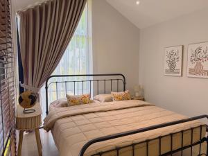 a bedroom with a bed and a large window at Four Moon Khaoyai in Pong Talong