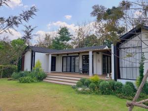 a small white house with a porch at Four Moon Khaoyai in Pong Talong