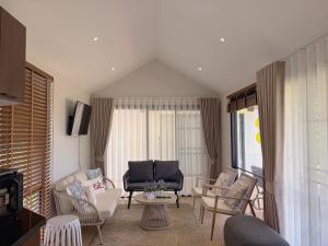a living room with chairs and a couch and a table at Four Moon Khaoyai in Pong Talong