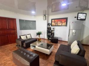 a living room with two couches and a refrigerator at Hotel Sabana Hilton in Madrid