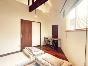 a room with two beds and a table in it at Shimanto Hutte in Shimanto-cho