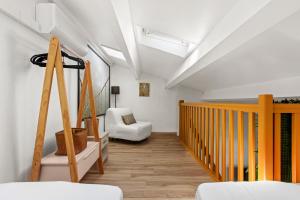 a room with a wooden staircase and a white chair at Moréa - residence avec piscine in Fréjus +16 photos