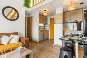 a living room and kitchen with a couch and a table at Moréa - residence avec piscine in Fréjus