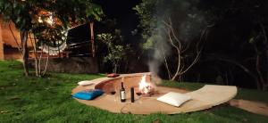 a fire pit in the grass in a yard at night at Nossa Casa em Lençóis - Bahia in Lençóis +17 photos