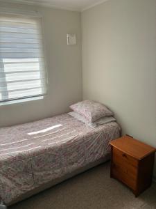 a small bedroom with a bed and a window at Pieza privada en casa in San Pedro de la Paz