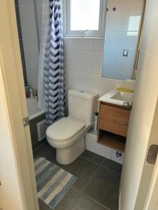a bathroom with a toilet and a sink and a window at Pieza privada en casa in San Pedro de la Paz