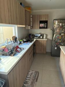 a kitchen with a sink and a refrigerator at Pieza privada en casa in San Pedro de la Paz