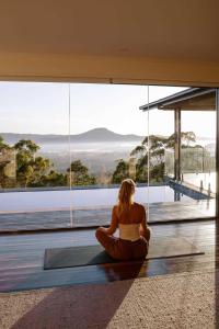 a woman sitting on the floor in front of a window at Wilderness House in Kulangoor +21 photos
