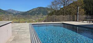 a swimming pool with a fence and mountains in the background at Landhaus Pool and Relax in Bruck an der Mur