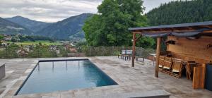 a swimming pool on a patio with mountains in the background at Landhaus Pool and Relax in Bruck an der Mur +60 photos