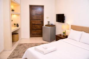 a bedroom with a white bed and a television at Hur palace pyramids view in Cairo