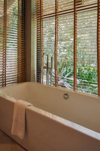 a white bath tub in a bathroom with windows at Ma'oni Seascape Villas in Panglao Island +13 photos