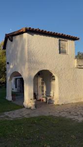 a white building with a bench in a yard at Casa de Barro in Junín