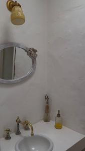 a bathroom sink with a mirror and a light at Casa de Barro in Junín