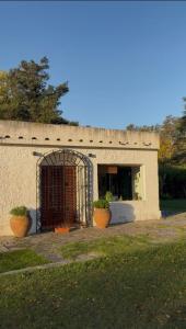 a building with a gate and two potted plants at Casa de Barro in Junín +14 photos